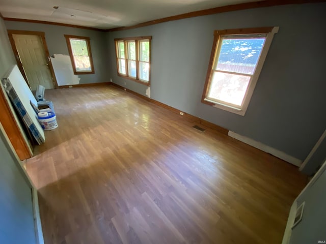 unfurnished living room with light wood-type flooring and crown molding