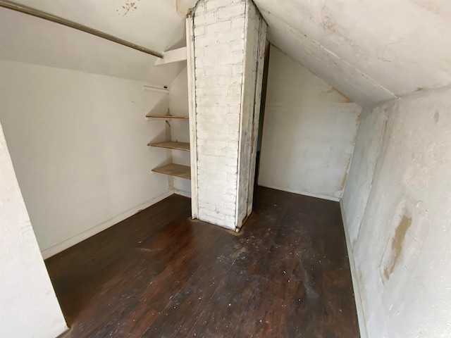 additional living space with dark hardwood / wood-style floors and vaulted ceiling