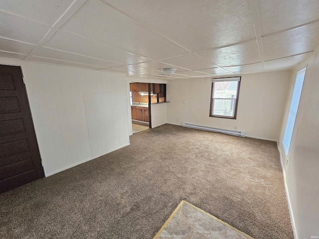 spare room featuring carpet flooring and a baseboard heating unit