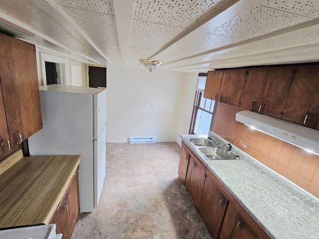 kitchen featuring white refrigerator, stove, sink, a baseboard radiator, and decorative backsplash