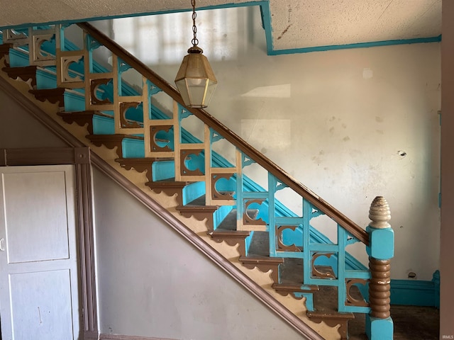 staircase featuring a textured ceiling