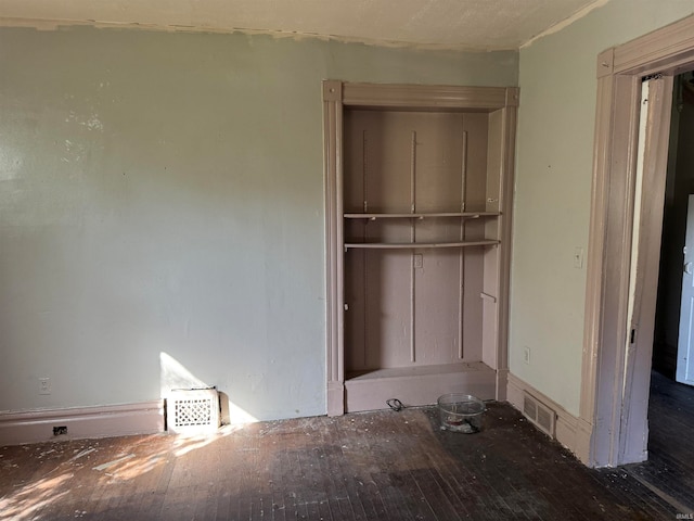 unfurnished bedroom with a closet and dark hardwood / wood-style flooring