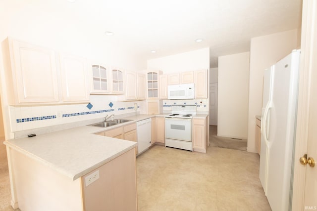 kitchen with white appliances, backsplash, sink, and kitchen peninsula