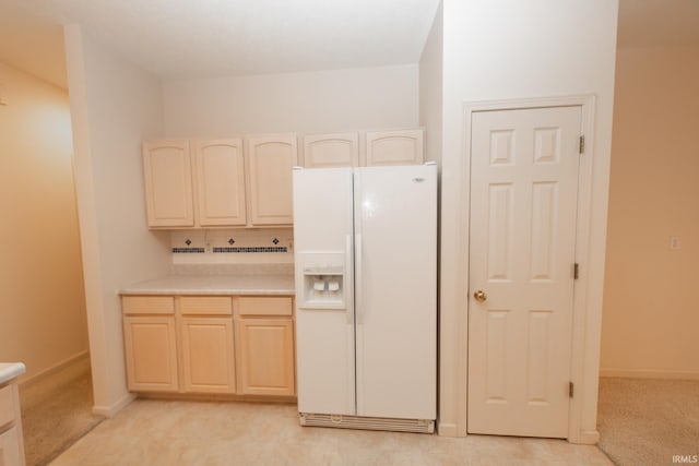 kitchen with white refrigerator with ice dispenser and decorative backsplash