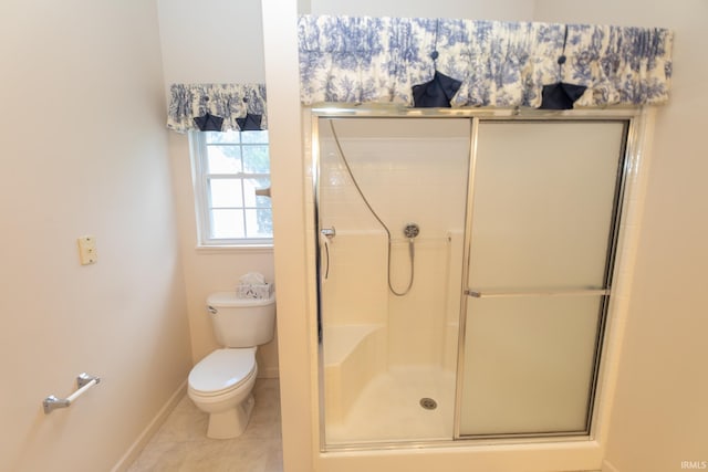 bathroom with tile patterned flooring, walk in shower, and toilet