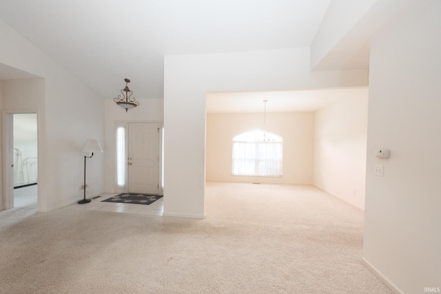 carpeted foyer entrance featuring vaulted ceiling