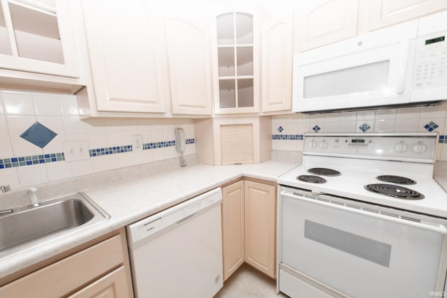 kitchen featuring sink, white appliances, and decorative backsplash