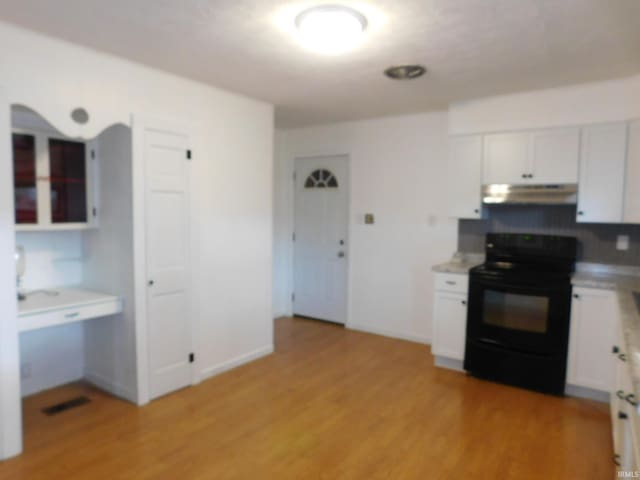 kitchen with light hardwood / wood-style floors, black electric range, and white cabinetry