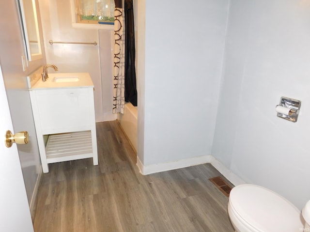 full bathroom with vanity, hardwood / wood-style flooring, toilet, and shower / bathtub combination with curtain