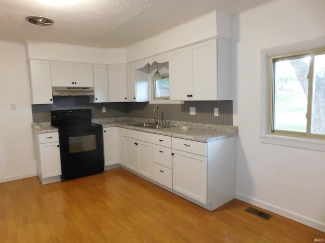 kitchen featuring light hardwood / wood-style flooring, black range with electric stovetop, sink, backsplash, and white cabinetry