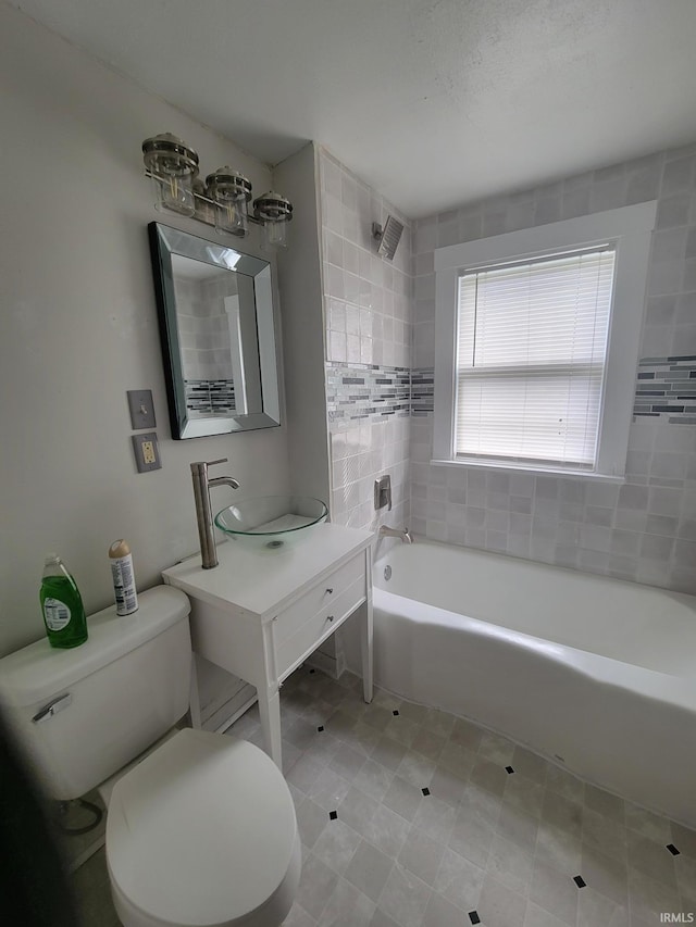 full bathroom featuring vanity, tiled shower / bath combo, and toilet