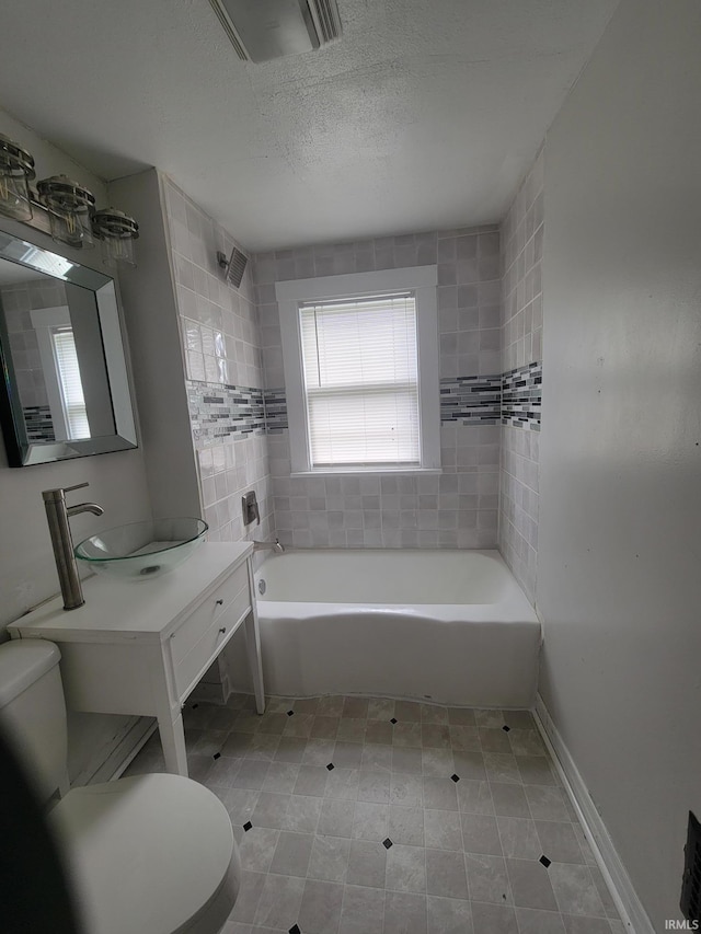 bathroom with vanity, toilet, and a textured ceiling