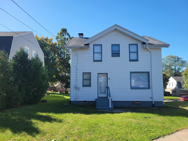 rear view of property with a yard