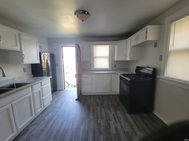 kitchen featuring black range with electric cooktop, white cabinetry, sink, and dark hardwood / wood-style floors