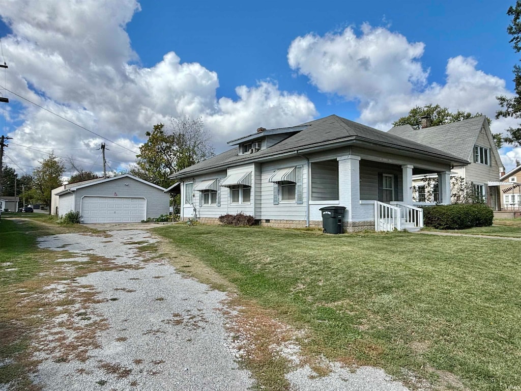 view of front of house with a front yard, a garage, and an outdoor structure