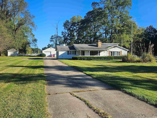 view of front of property featuring a front lawn and a shed