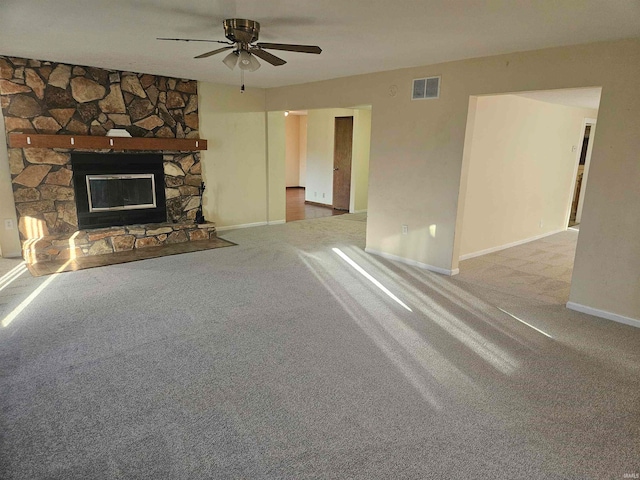 unfurnished living room featuring ceiling fan, a fireplace, and carpet flooring