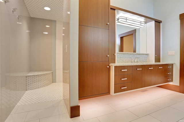 bathroom featuring walk in shower, vanity, and tile patterned flooring