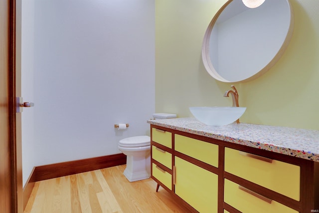 bathroom with hardwood / wood-style flooring, vanity, and toilet