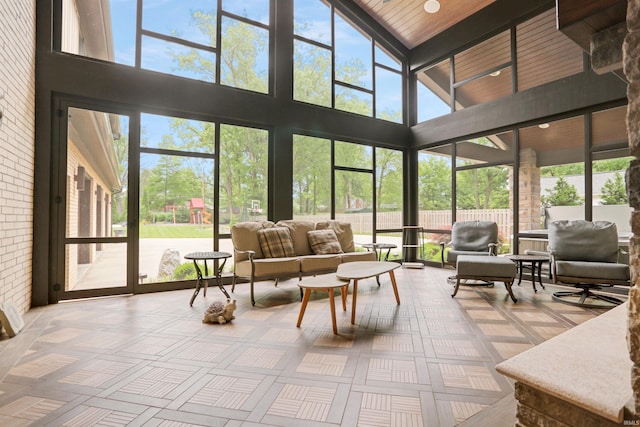 sunroom featuring lofted ceiling with beams and wooden ceiling