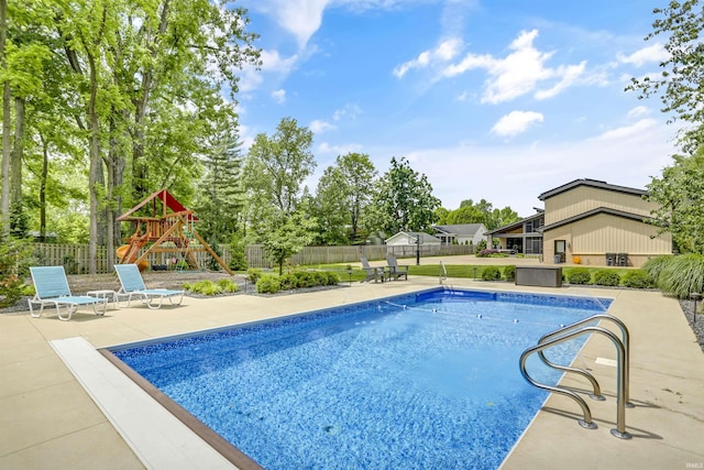 view of swimming pool featuring a playground and a patio area