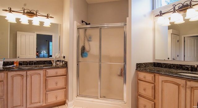 bathroom featuring a shower with door, vanity, and tile patterned flooring