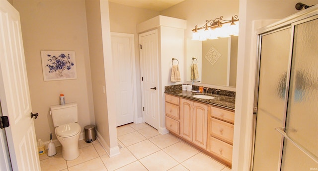 bathroom with vanity, toilet, tile patterned floors, and walk in shower