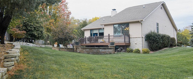 back of property featuring a wooden deck and a lawn