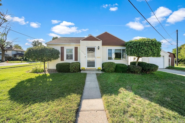 bungalow-style home featuring an outbuilding, a front yard, and a garage