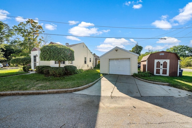 view of front of property featuring a garage, a storage shed, and a front yard