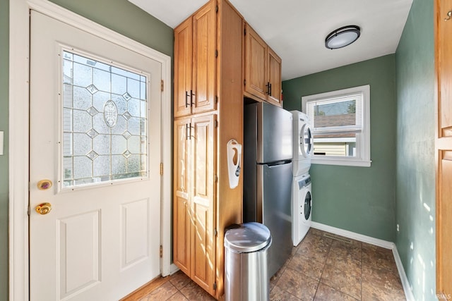 kitchen featuring stacked washer and dryer, stainless steel fridge, and tile patterned flooring