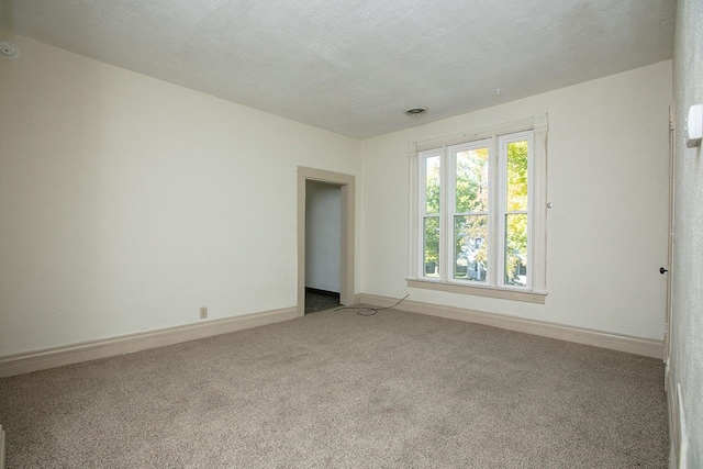 carpeted spare room featuring a textured ceiling