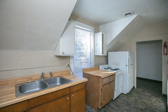 kitchen featuring lofted ceiling, sink, white cabinetry, and white stove