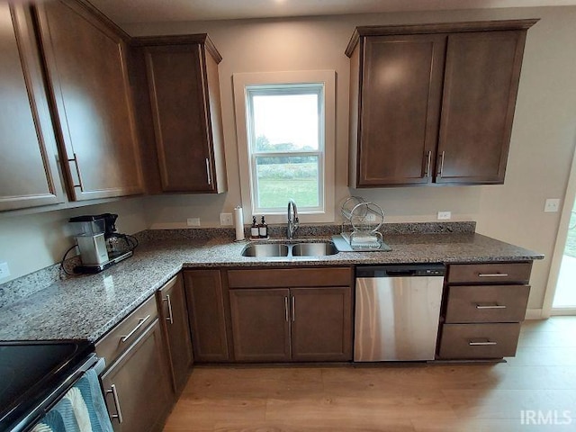 kitchen featuring sink, light hardwood / wood-style floors, appliances with stainless steel finishes, dark brown cabinets, and stone countertops