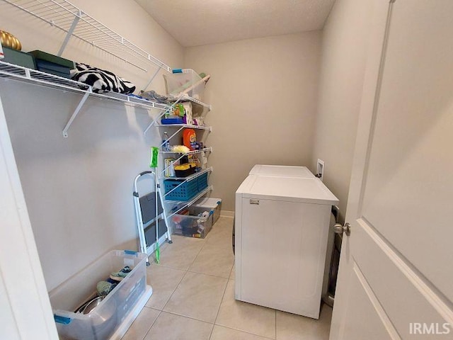 clothes washing area featuring light tile patterned floors and independent washer and dryer