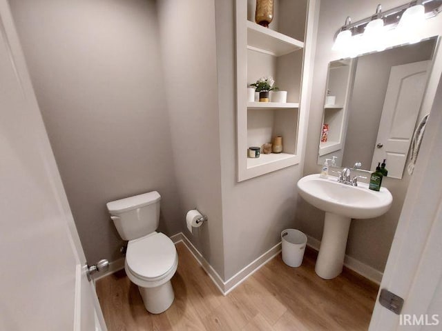 bathroom featuring wood-type flooring, sink, and toilet