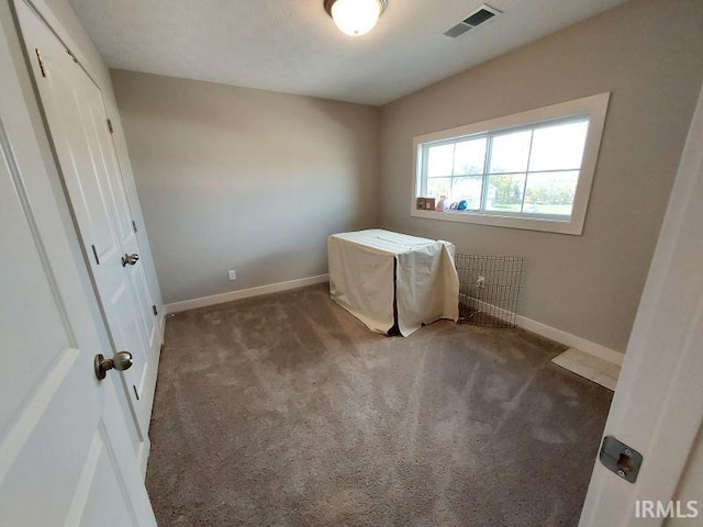 unfurnished bedroom with dark colored carpet