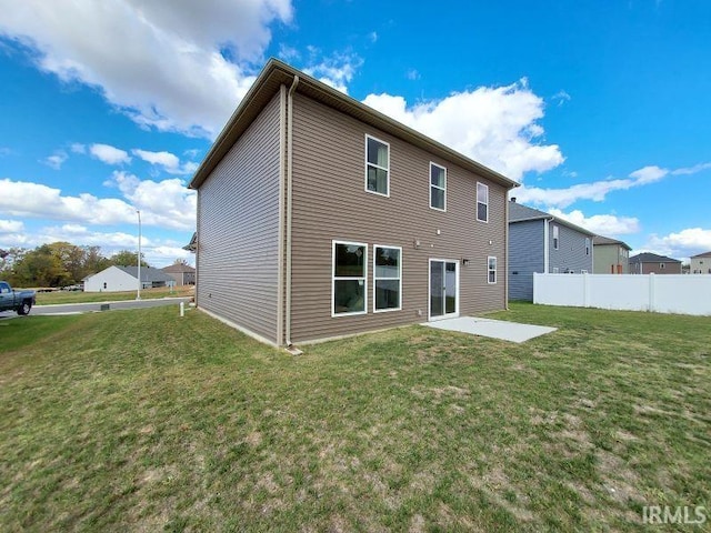 back of house featuring a patio and a lawn