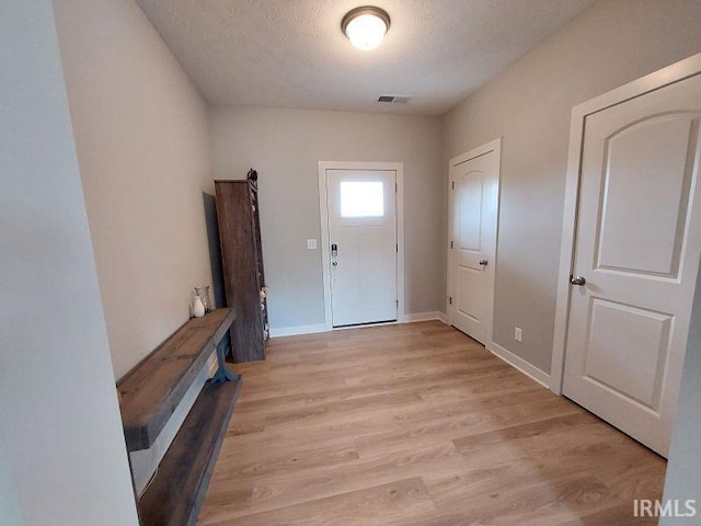 entrance foyer with a textured ceiling and light hardwood / wood-style floors