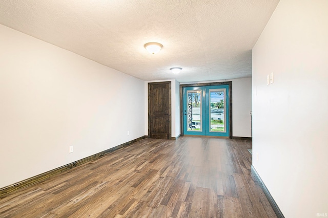 unfurnished room with a textured ceiling and dark wood-type flooring