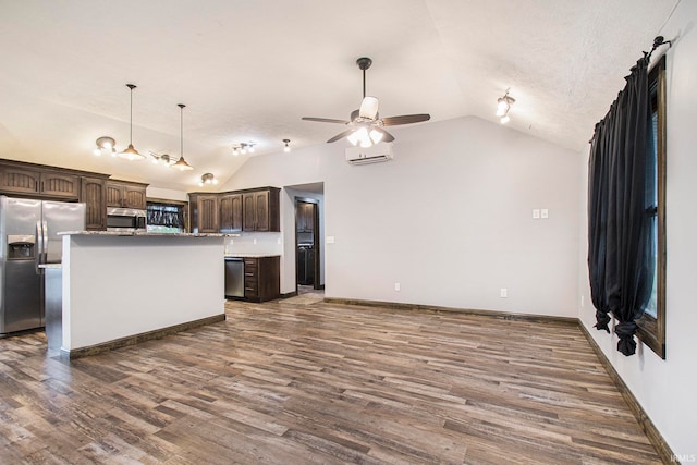 kitchen with a kitchen island, dark wood-type flooring, dark brown cabinets, vaulted ceiling, and appliances with stainless steel finishes