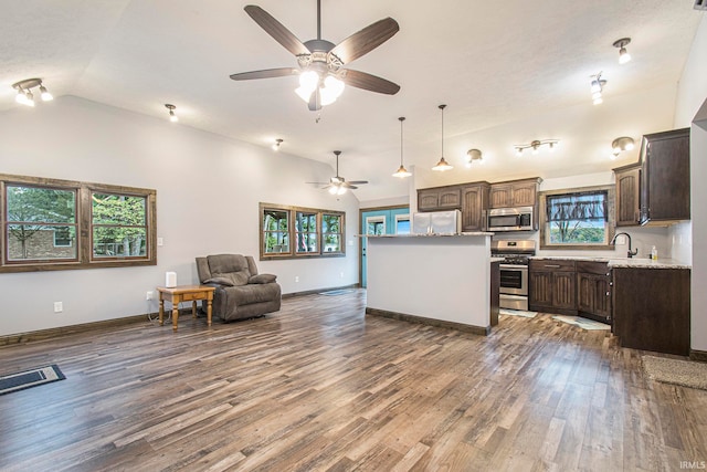 kitchen with stainless steel appliances, wood-type flooring, vaulted ceiling, and plenty of natural light