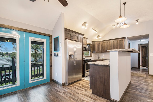 kitchen featuring hardwood / wood-style flooring, vaulted ceiling, pendant lighting, dark brown cabinetry, and stainless steel appliances