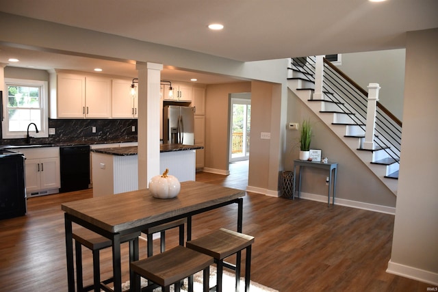 kitchen with white cabinetry, a center island, dishwasher, and stainless steel refrigerator with ice dispenser