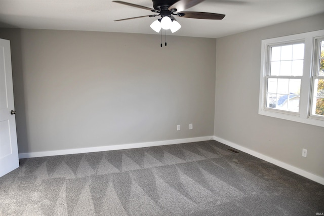 unfurnished room with dark colored carpet and ceiling fan