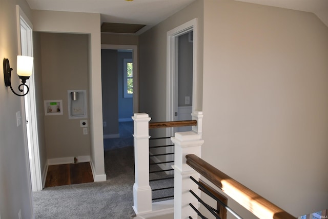 hall featuring baseboards, an upstairs landing, and carpet