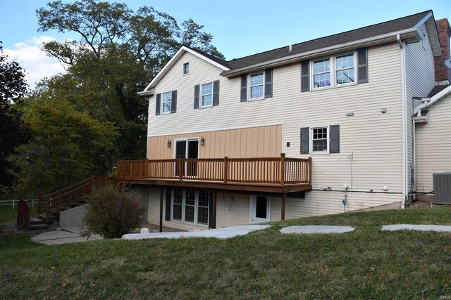 back of property with a wooden deck, a yard, and central air condition unit