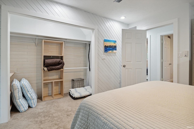 carpeted bedroom featuring wood walls