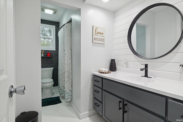 bathroom with toilet, vanity, and tile patterned flooring