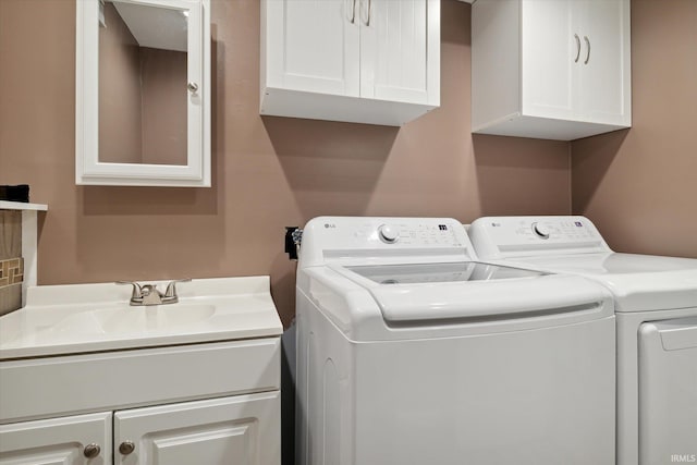 laundry room with cabinets, sink, and separate washer and dryer